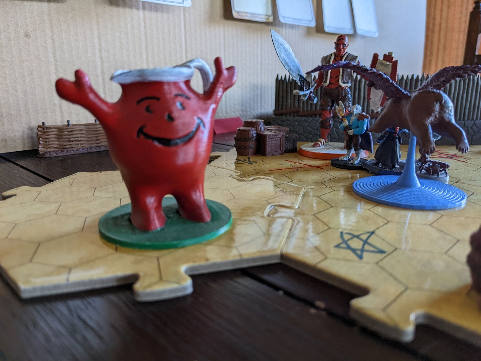 Oh yeah minis on a battlemap. a large pitcher with arms, legs, and a big smile, full of red liquid, is in the left foreground, and a large quinametzin and winged bear in the back to the right, with a Silver dragonborn bearing a greataxe stands between.