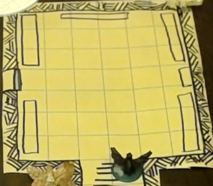 Map of the laboratory.  Tables line the left and right, a door leads off to the left, bookshelf to the right.